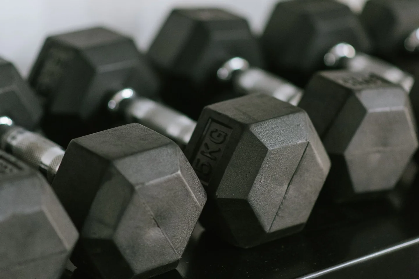 Hex dumbbells stored on a gym rack.