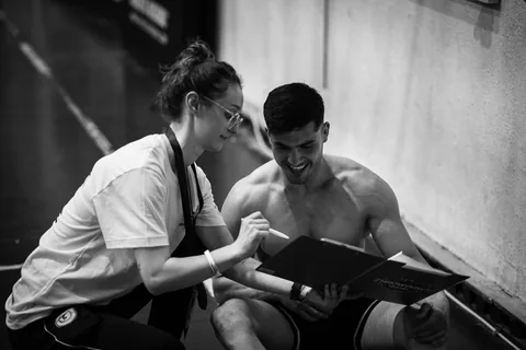 A trainer explaining information to a gym user.