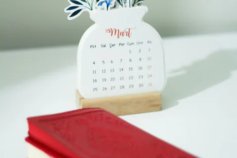 A calendar and notebook on a desk.