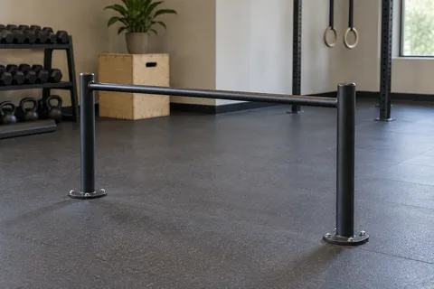 Fixed gym exercise bar at waist height with clear floor space.