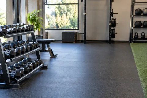 Clear exercise lane beside light dumbbells in a quiet gym.